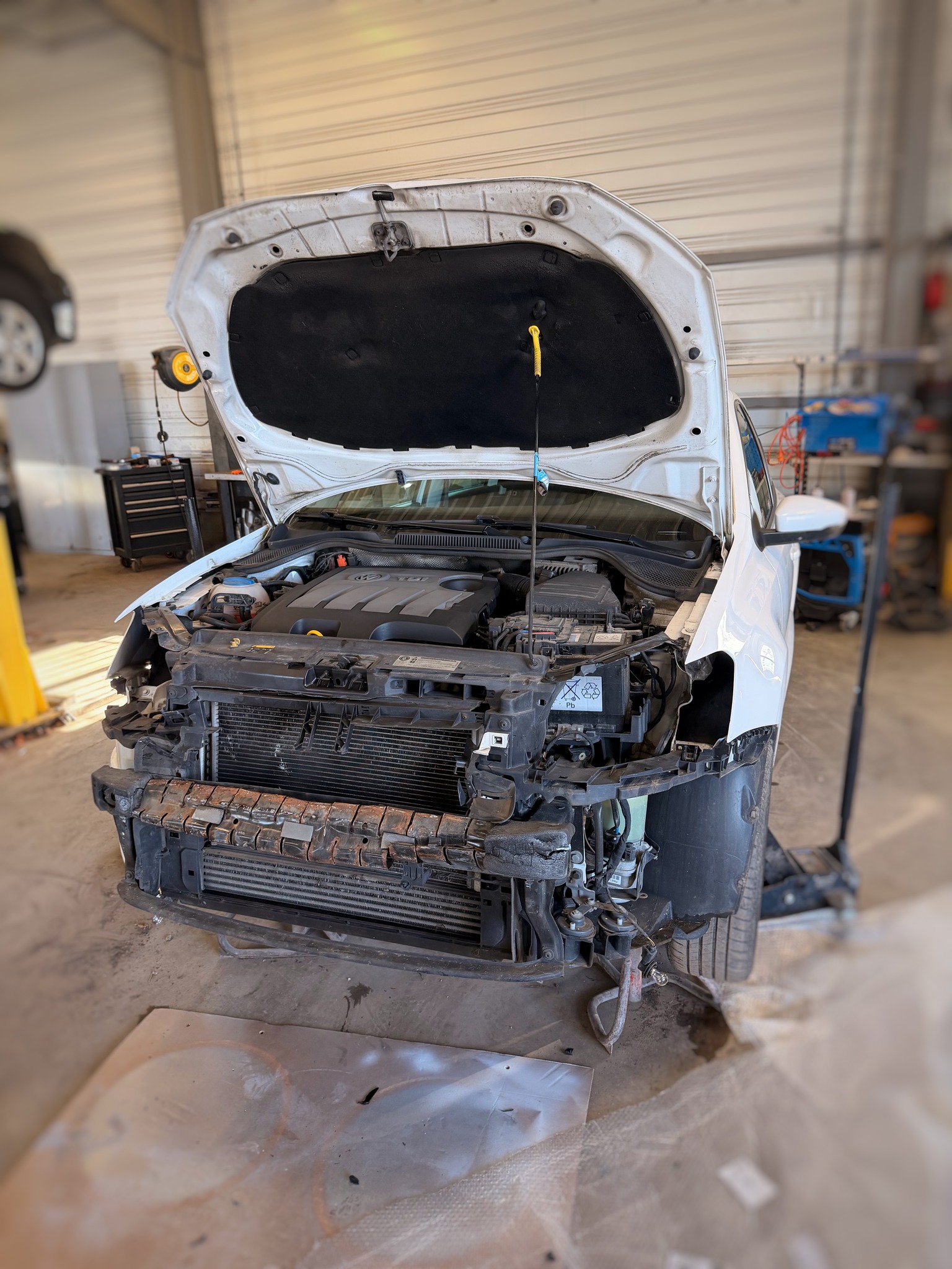 VW Polo démontée en atelier – capot ouvert, travail de carrosserie en cours